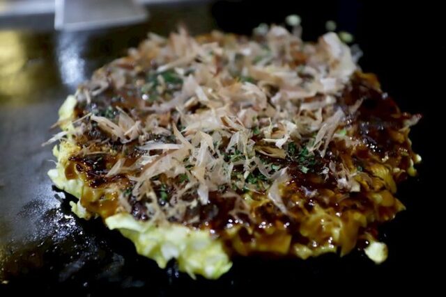 Okonomiyaki topped with bonito flakes at Okonomiyaki Hayashi