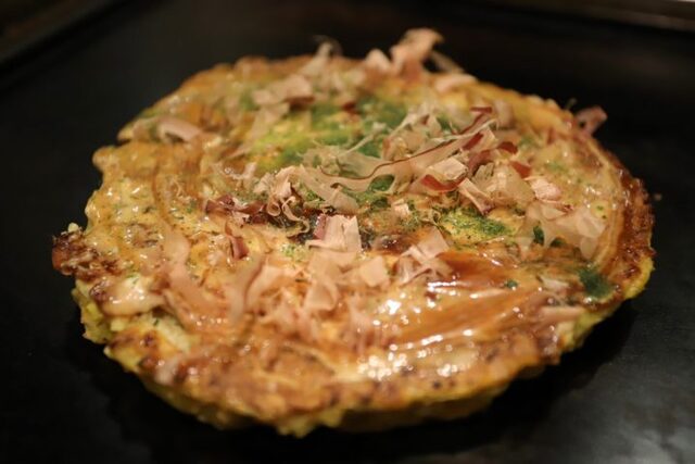 Okonomiyaki topped with bonito flakes at Okonomiyaki Dan