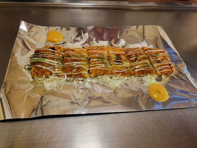 Sliced okonomiyaki with sauce and mayonnaise at Yaoya