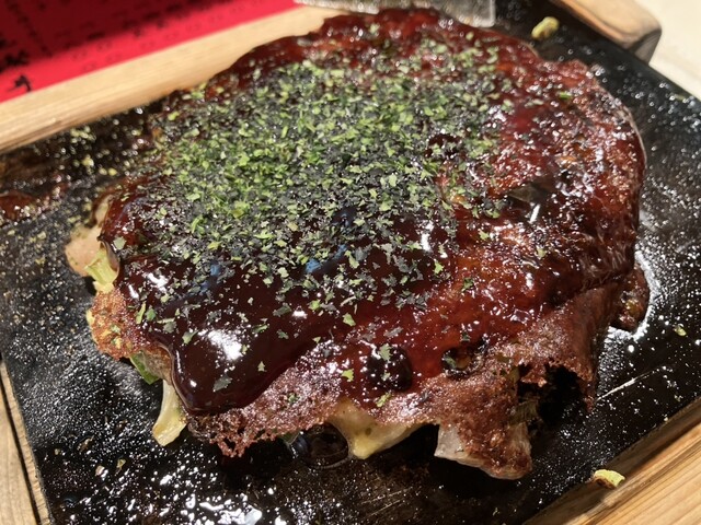 Okonomiyaki topped with sauce and seaweed at Asai