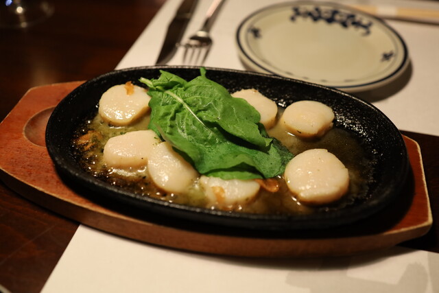 Scallops and greens served on a sizzling plate at Myogetsubo