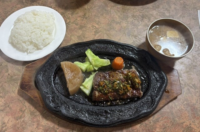 Steak meal served on a sizzling plate at Steak Ishii